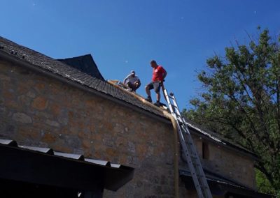 Les ouvriers sur le toit en train de faire un passage par tuile