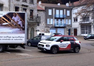 Camion et la voiture de Languedoc Isolation garés devant une maison